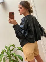 Campera marrón de cuero con cierre frontal, corte oversize, mangas abullonadas y puños ajustados.