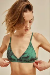 Conjunto de bikini blanco con textura, compuesto por un corpiño de triángulo fijo con breteles regulables y almohadillas desmontables, y una bombacha vedetina con frunce elástico en los costados.