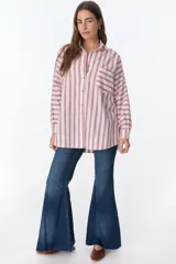 Camisa blanca con rayas verticales rojas, de corte holgado, manga larga y bolsillo en el pecho.