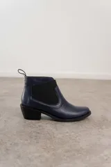 Botín Chelsea de cuero marrón con elástico lateral y tacón bajo.