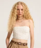 Blusa cropped sin breteles color blanco con pequeños apliques dorados.