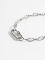 Pulsera de acero quirúrgico plateado, con diseño de eslabones y un dije en forma de mosquetón.