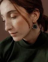 Aros colgantes con dije circular de resina verde oscuro con borde de strass plateado y gancho de acero quirúrgico dorado.