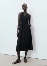 Vestido midi negro sin mangas, con escote en V, cierre frontal de botones y trabillas para cinturón ajustable. Diseño evasé con bolsillos laterales.