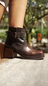 Botas cortas color gris con efecto desgastado, con hebillas doradas y taco cuadrado.