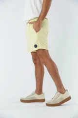 Short de baño celeste liso, con cintura elástica ajustable con cordón negro, dos bolsillos delanteros y uno trasero.