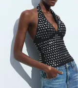 Top negro con cuello halter y espalda descubierta, con apliques de tachas plateadas.