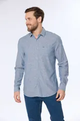 Camisa de lino color beige, de manga larga, con cuello clásico y bolsillo en el pecho.