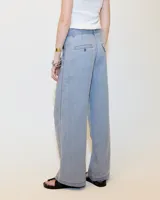 Pantalón gris de lino, de pierna ancha con pinzas, tiro medio, bolsillos laterales inclinados, raya de aplomo y bolsillos traseros ojal y con tapa. Tiene cierre y botón en la cartera y cintura interna prearmada.