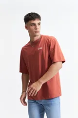 Remera color ladrillo de manga corta con corte oversize y estampado frontal con la frase "creative spark mistral".