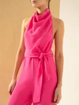 Enterito rosa con escote buche y espalda descubierta, de corte ajustado en la cintura y lazo para ajustarlo.