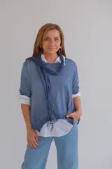 Sweater celeste de tejido de punto con cuello redondo y mangas largas. Incluye una camisa blanca de mangas largas y una bufanda azul con detalles de encaje.