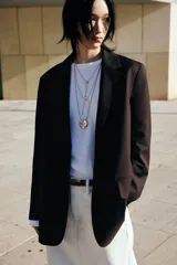 Blazer marrón oscuro de corte recto, con solapas de muesca, hombreras y bolsillos ribeteados con solapa.