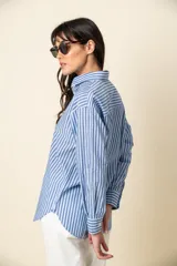 Camisa de manga larga a rayas verticales color violeta y blanco, con cuello clásico y corte recto.