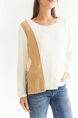 Remera de algodón color blanco con manga larga, corte irregular y franja lateral color beige.