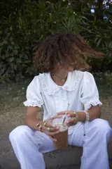 Brazalete rígido dorado con forma de caracola en los extremos.