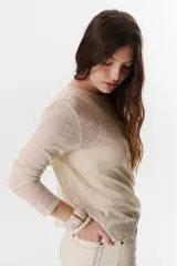 Sweater beige de tejido de punto calado, con mangas largas y cuello redondo. Confeccionado en viscosa y poliéster.