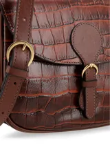 Cartera bandolera de cuero color marrón con textura tipo cocodrilo, cierre con hebilla y broche a presión, logo metálico en el interior y bolsillo interno con cierre.