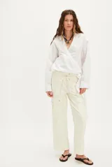 Pantalón cargo color crema, de corte recto y tiro alto, con bolsillos laterales con solapa y ajuste con cordón en la cintura.