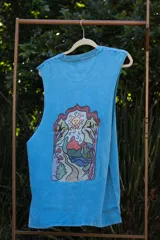 Musculosa celeste con estampado de tres hongos rojos y texto "Tuya".