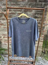 Remera azul con efecto lavado, de corte holgado y manga corta. Estampa trasera con la frase "Cherry Season" y un diseño pixelado de cerezas.