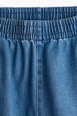 Pantalón culotte de denim azul claro, con cintura elástica fruncida, bolsillos laterales y corte holgado.