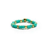Anillo elástico de acero con cuentas pequeñas color verde agua y detalles dorados.
