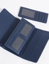 Billetera azul de cuero sintético con múltiples compartimentos para tarjetas y billetes, tarjetero removible, cierre con broche y herrajes plateados.