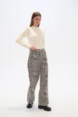Pantalón ancho de algodón con estampado abstracto en tonos beige y negro, de tiro alto y con bolsillos laterales.