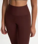 Conjunto deportivo color marrón compuesto por un top de breteles anchos y calzas largas de cintura alta.