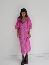 Vestido midi de corte holgado con estampado floral en tonos rosa y naranja, escote en V y mangas cortas amplias.