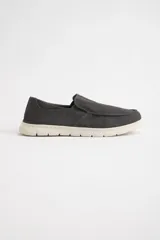Mocasines náuticos grises de lona con suela blanca.