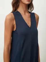 Mono largo color beige, de corte holgado, con cuello redondo y mangas cortas. Presenta bolsillos laterales y detalle de costuras verticales en el frente.