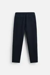 Pantalón azul marino de corte recto, confeccionado en tejido de algodón y lino. Tiene cintura elástica ajustable con cordón, bolsillos delanteros y traseros de vivo. Cierre frontal con cremallera y botón.