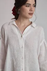 Camisa de lino color terracota, con cuello camisero, botones frontales y mangas amplias de tres cuartos.