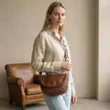 Bandolera marrón de cuero sintético con correa ancha estampada ajustable.