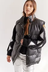 Campera puffer negra de cuero sintético, con cuello alto, cierre frontal con cremallera y botones a presión, y bolsillos laterales.