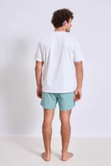 Short de baño azul con logo blanco en la pierna izquierda.