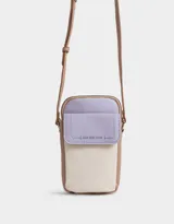 Porta celular de cuerina texturada con bolsillo frontal con solapa, correa regulable, acceso mediante cierre superior y puller de cuerina estampada, solapa con broche con botón para cerrado y tag de metal.