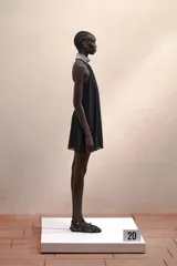 Vestido corto negro con cuello halter con joyas, caída amplia y espalda descubierta.