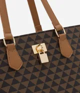 Bolso shopper grande de cuero sintético color marrón con estampado de triángulos negros. Tiene doble asa de mano color marrón, cierre superior con cremallera y detalle de candado decorativo dorado.