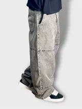 Pantalón baggy de denim gris con efecto lavado y líneas verticales.