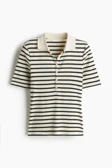 Remera polo entallada en punto acanalado a rayas horizontales negras y crudas, con cuello clásico y tapeta de botones.