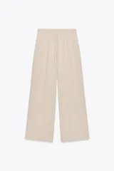 Pantalón ancho color beige, de tiro alto con cintura elástica.