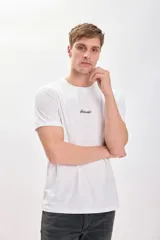 Remera blanca de manga corta con cuello redondo y estampado trasero en tono sepia/marrón. El estampado incluye el texto "Aloha Hawaii" y una ilustración de una caseta de salvavidas con el texto "Paradise of the Pacific".