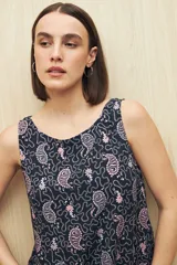Vestido largo sin mangas con estampado animal print, escote redondo y corte con volado en el ruedo. Su silueta amplia y fluida ofrece movimiento y frescura, mientras que el tejido de viscosa aporta una textura suave y liviana.