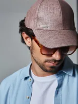 Gorra de béisbol azul de lino con hebilla metálica ajustable en la parte posterior y logo de la marca en el lateral.