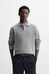 Polo marrón de punto con hilatura de algodón, corte relaxed fit, cuello solapa con cierre frontal de botonadura, manga larga y acabados en rib.