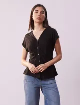 Remera blanca de lino, marca Zac & Rachel, con escote en V, abertura con botones y frunce en la parte delantera.