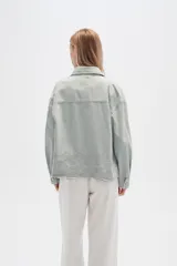 Campera de jean color crudo, de corte recto, con cuello clásico, cierre frontal con botones metálicos, dos bolsillos con solapa en el pecho y bajo con detalle de bordado calado.